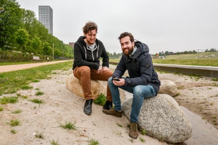 Luuk en Vincent zittend op stenen in het Spoorpark